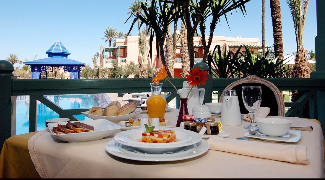 Petit-déjeuner servi en terrasse face aux palmiers